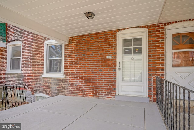 view of exterior entry featuring brick siding