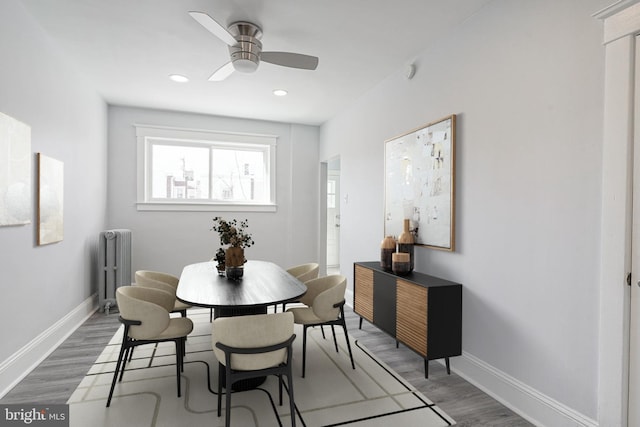 dining room with radiator heating unit, baseboards, ceiling fan, and wood finished floors