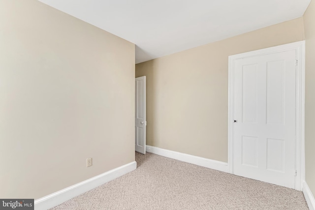 unfurnished room featuring carpet flooring and baseboards