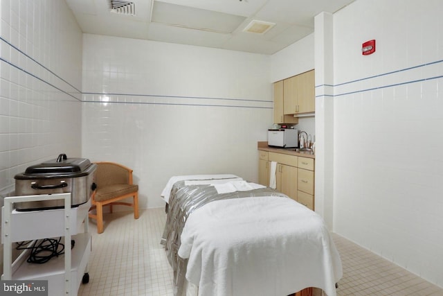 bedroom with visible vents and tile walls