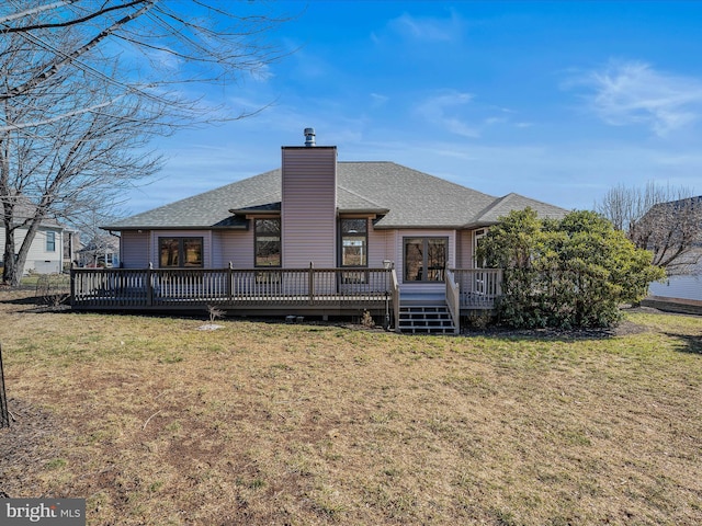 back of house featuring a deck, roof with shingles, a yard, and a chimney