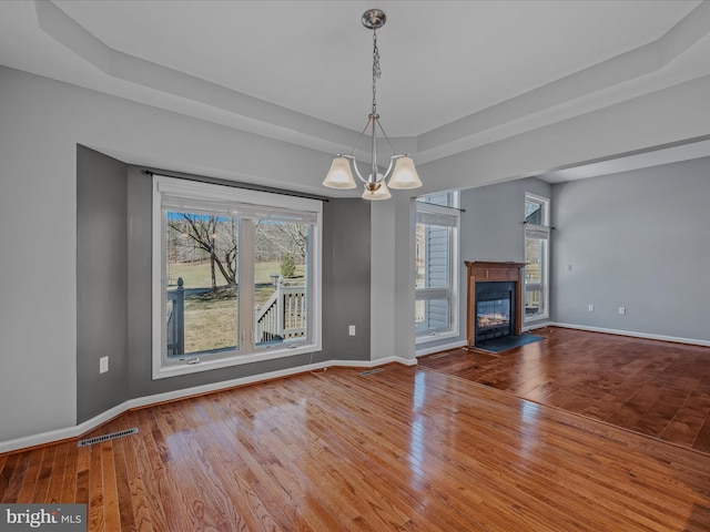 unfurnished living room with a glass covered fireplace, baseboards, and hardwood / wood-style flooring