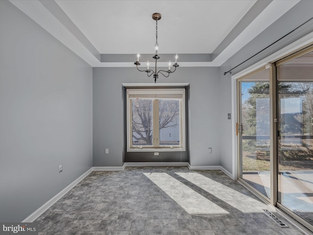 unfurnished dining area featuring an inviting chandelier, baseboards, visible vents, and a raised ceiling