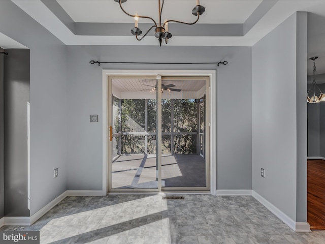 interior space with visible vents, baseboards, and ceiling fan with notable chandelier