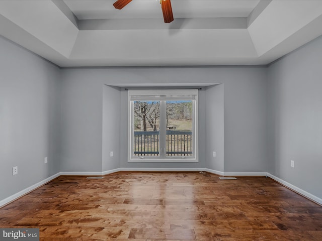 spare room with ceiling fan, baseboards, and wood finished floors