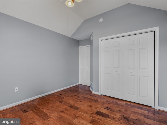 unfurnished bedroom with lofted ceiling, visible vents, baseboards, a closet, and hardwood / wood-style floors