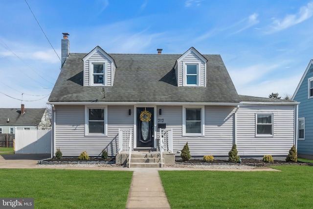 new england style home featuring a front yard and fence