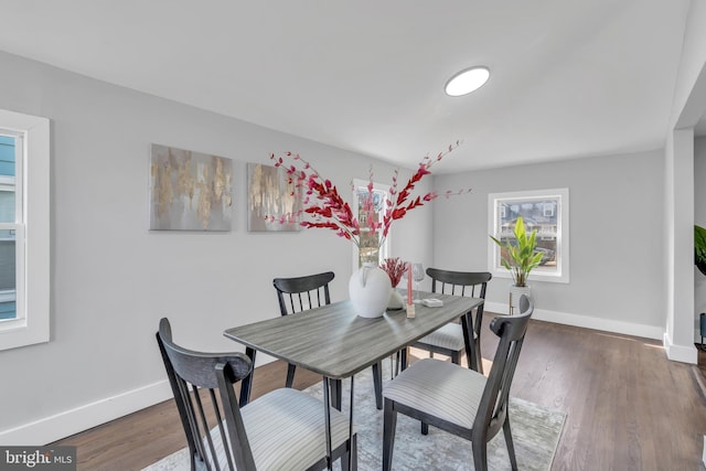 dining space featuring wood finished floors and baseboards