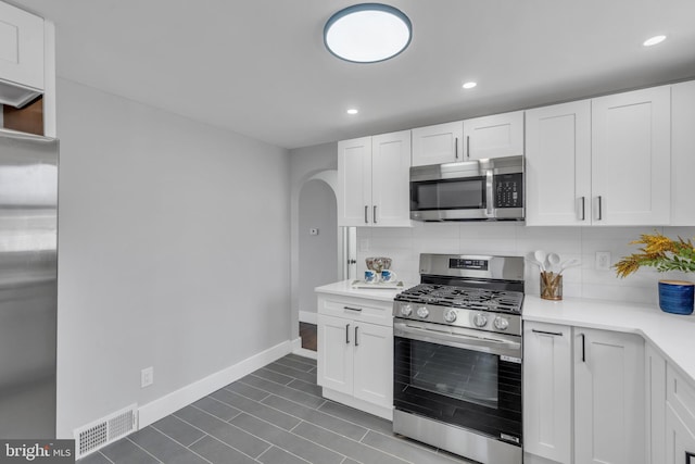 kitchen featuring tasteful backsplash, visible vents, appliances with stainless steel finishes, light countertops, and white cabinetry