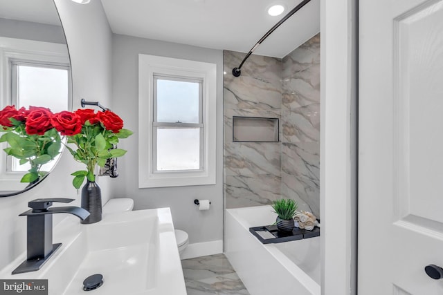 full bath with marble finish floor, toilet, washtub / shower combination, a sink, and baseboards