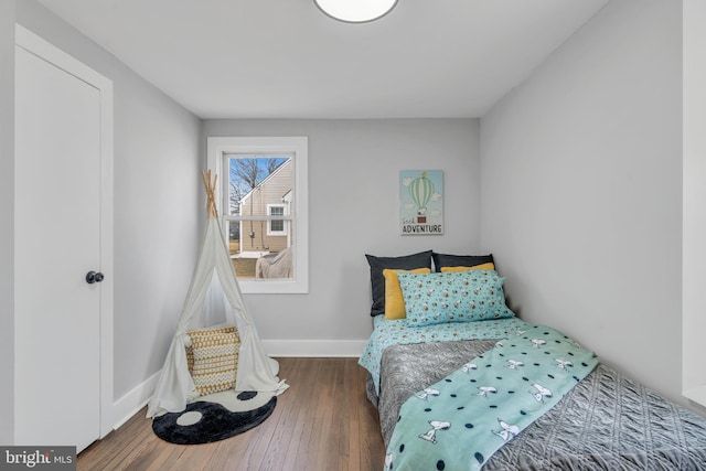 bedroom with wood-type flooring and baseboards