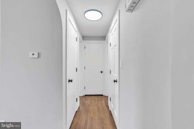 hall with visible vents and wood finished floors