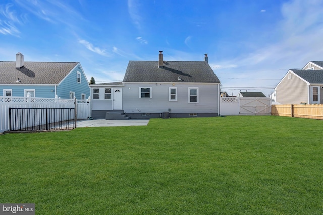 back of property featuring entry steps, a lawn, a fenced backyard, a gate, and a patio area