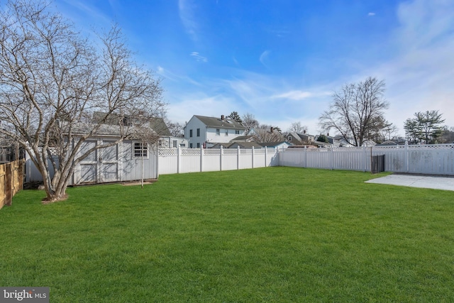 view of yard featuring an outbuilding, a storage unit, and a fenced backyard