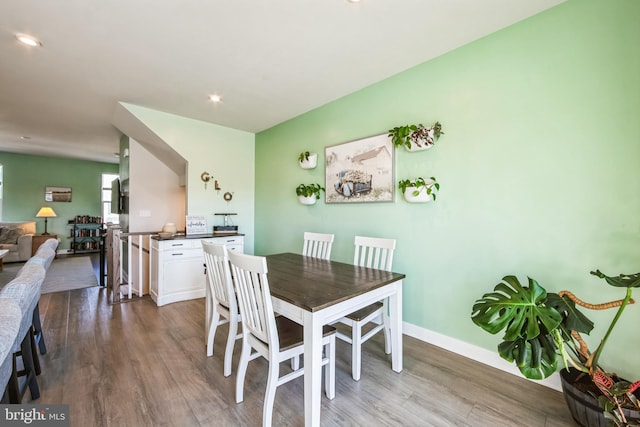 dining space with baseboards and dark wood-style flooring