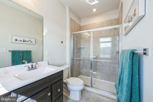 bathroom with vanity, a shower stall, toilet, and tile patterned flooring