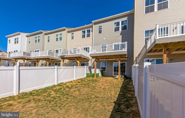 rear view of property featuring a residential view, a lawn, and a fenced backyard