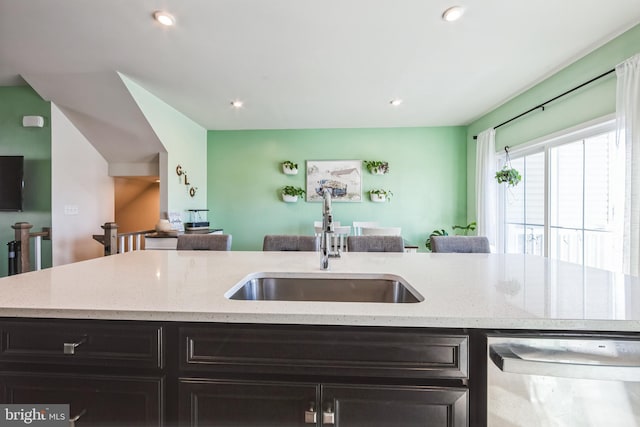 kitchen featuring a sink, stainless steel dishwasher, open floor plan, recessed lighting, and light stone countertops