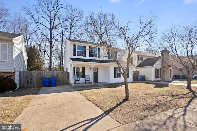 view of front of property featuring covered porch, fence, and concrete driveway