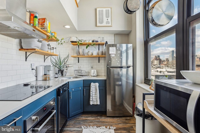 kitchen with appliances with stainless steel finishes, blue cabinets, open shelves, and exhaust hood