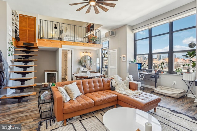 living area featuring stairs, wood finished floors, a towering ceiling, and baseboards