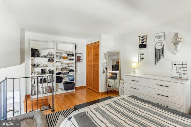 bedroom featuring a closet, wood finished floors, and baseboards