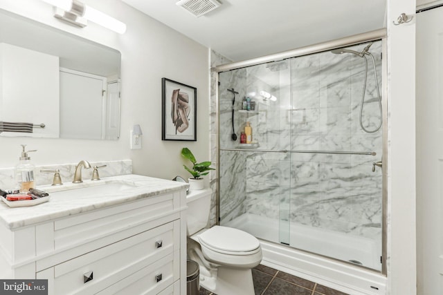 bathroom with toilet, vanity, visible vents, a marble finish shower, and tile patterned floors