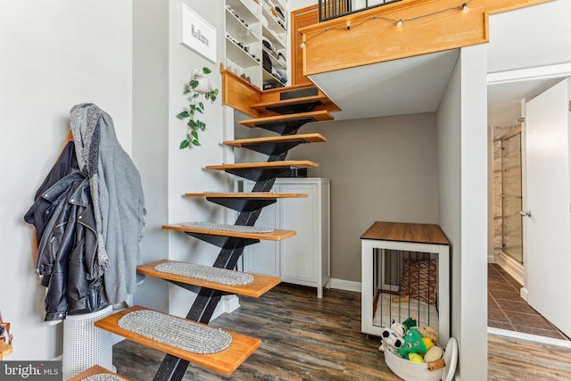 staircase with baseboards and wood finished floors