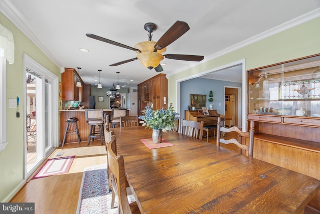 dining room with light wood finished floors, recessed lighting, crown molding, and a ceiling fan