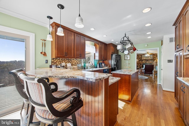 kitchen featuring plenty of natural light, a kitchen island, freestanding refrigerator, and a sink