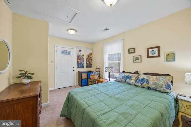 carpeted bedroom featuring attic access, visible vents, and baseboards