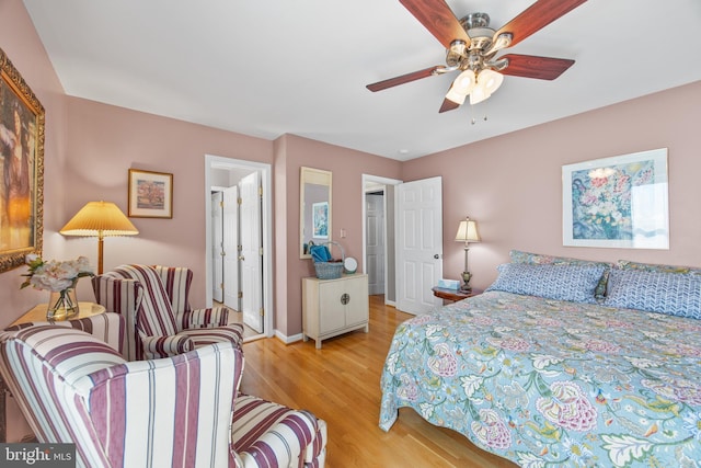 bedroom featuring baseboards, light wood-style floors, and ceiling fan