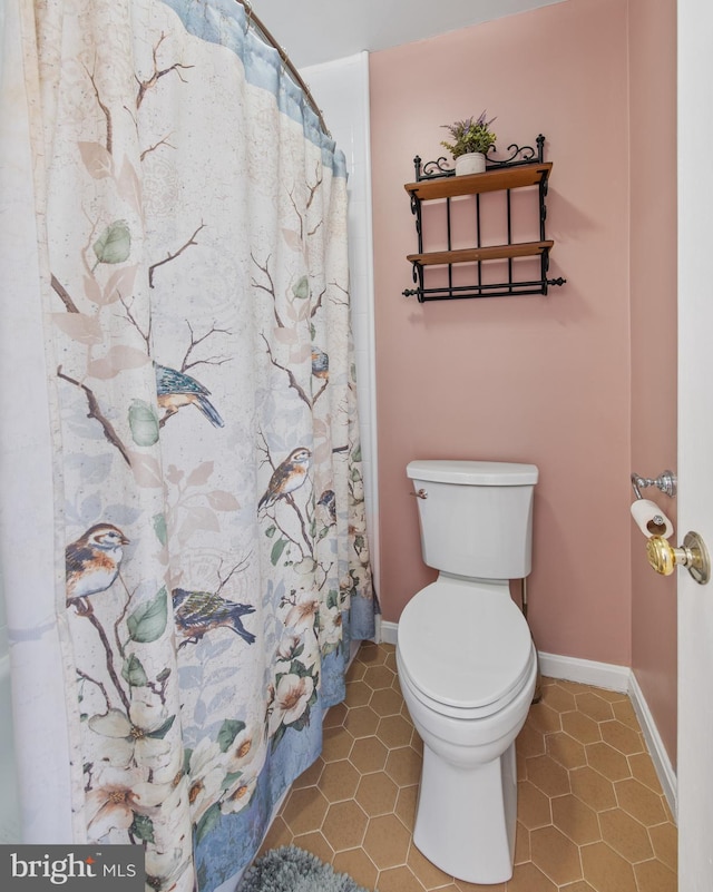 bathroom featuring tile patterned floors, baseboards, and toilet