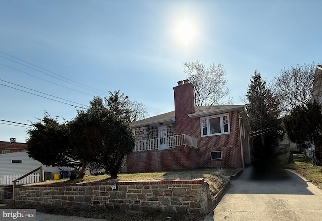 view of property exterior with brick siding and a chimney