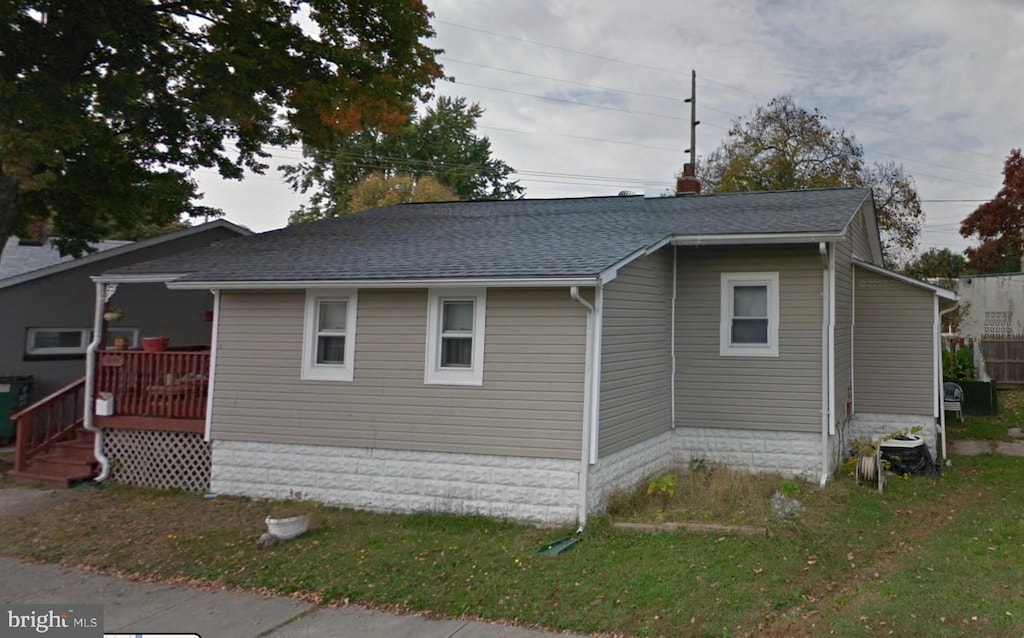 view of side of home featuring roof with shingles and a chimney