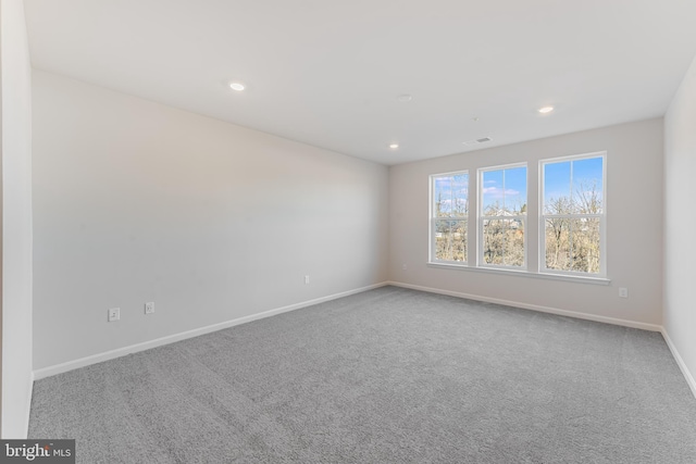 carpeted empty room featuring recessed lighting and baseboards