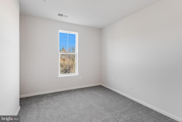 carpeted spare room featuring visible vents and baseboards