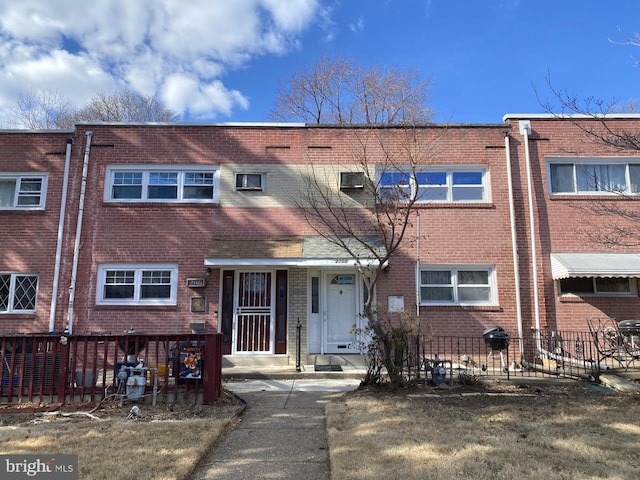 townhome / multi-family property with brick siding and fence