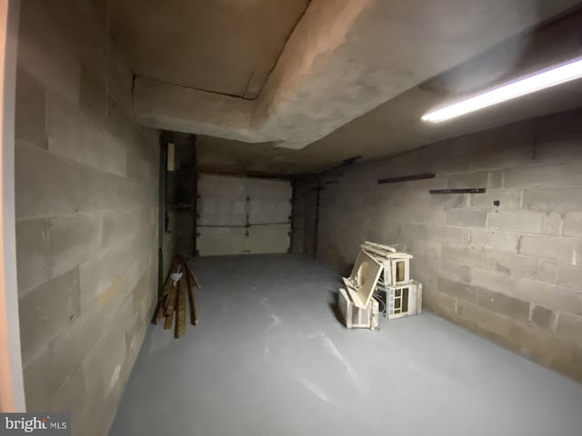 unfinished basement featuring concrete block wall