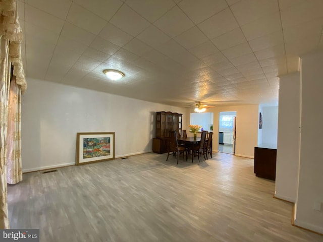 dining space with visible vents, baseboards, ceiling fan, and wood finished floors