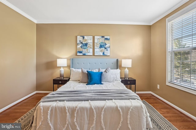 bedroom featuring crown molding, baseboards, and wood finished floors