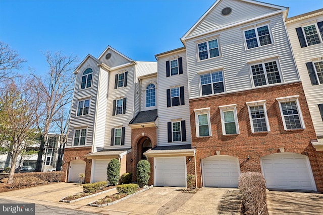 view of front of home featuring a garage, brick siding, and driveway