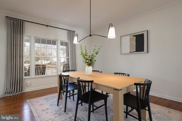 dining space with baseboards, ornamental molding, and wood finished floors