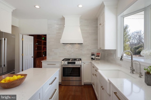 kitchen with recessed lighting, stainless steel appliances, white cabinets, custom exhaust hood, and decorative backsplash