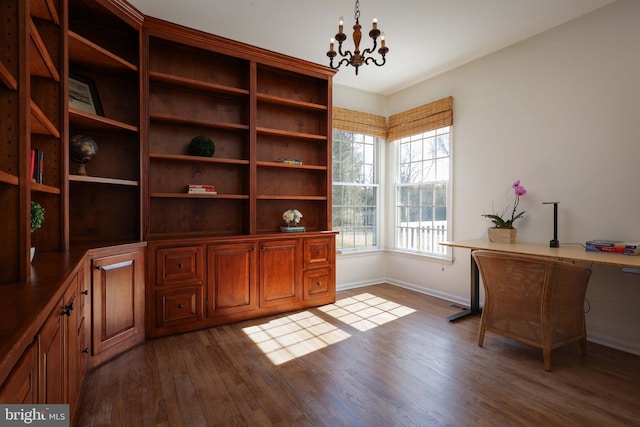 unfurnished office with baseboards, dark wood finished floors, and an inviting chandelier