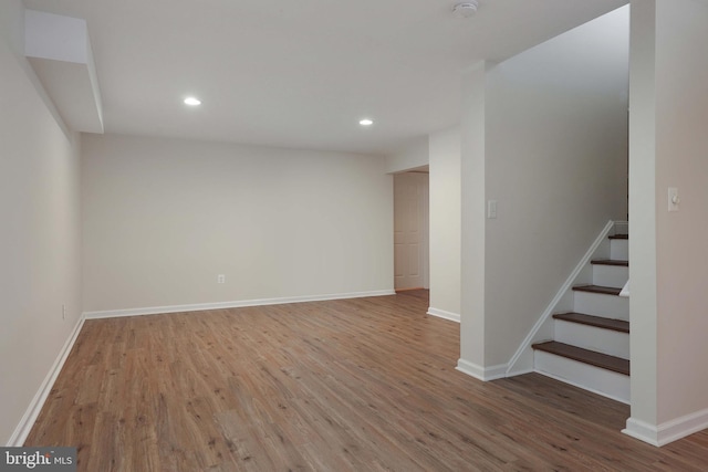 empty room with recessed lighting, baseboards, and wood finished floors