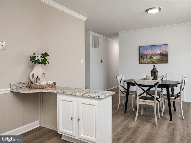 dining room featuring dark wood-style flooring and crown molding