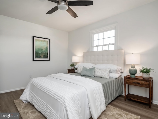 bedroom featuring baseboards, wood finished floors, and a ceiling fan