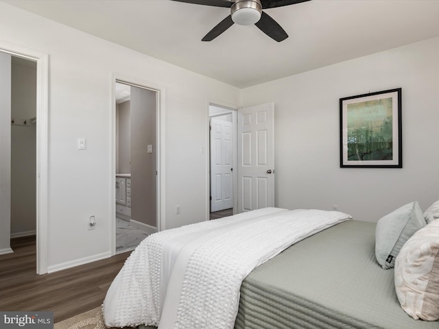 bedroom with connected bathroom, a ceiling fan, baseboards, and wood finished floors