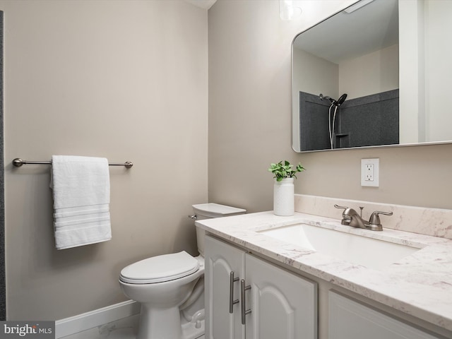 bathroom featuring vanity, toilet, baseboards, and marble finish floor